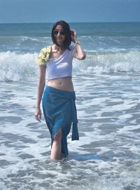 Portrait of young woman standing at beach