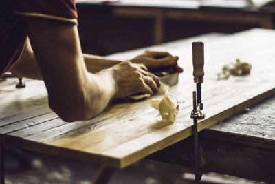 Cropped hands of man working on table at workshop