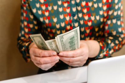 Woman counting money, economy concept, allocation of money. woman counting dollars at white table. 