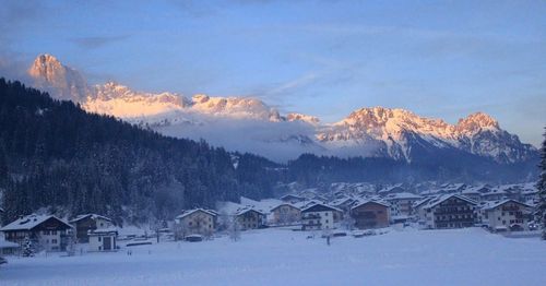 Houses on snowcapped mountains against sky