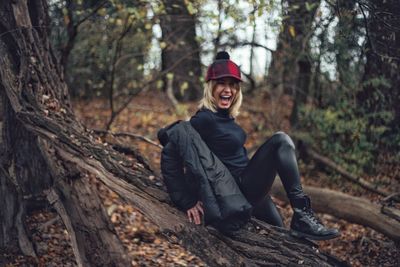 Portrait of man sitting on tree trunk