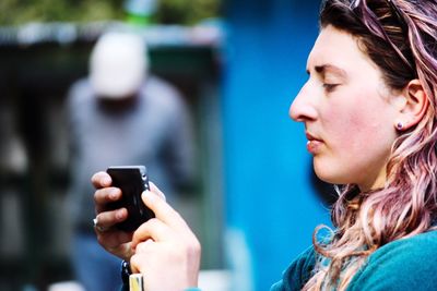 Side view of young woman using smart phone
