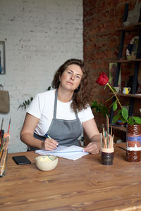 Portrait of young woman sitting on table