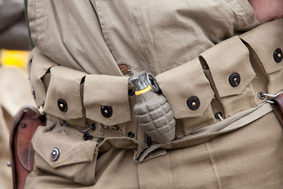 Midsection of soldier with hand grenade