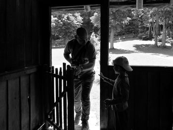 Man talking with son while standing by gate