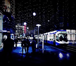 People in illuminated city at night