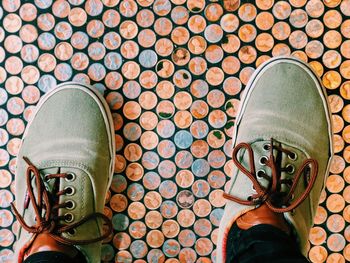 Low section of man standing on tiled floor