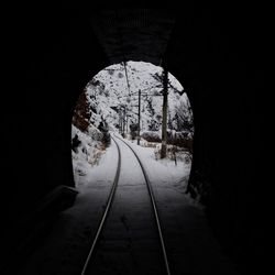 Railroad track passing through tunnel during winter