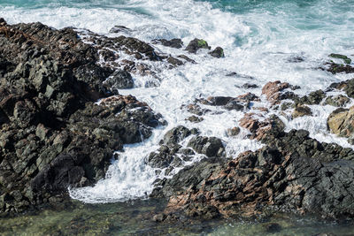 Ocean waves breaking on the rocks on the beach. 