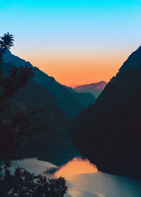 Scenic view of silhouette layered mountains against sky at sunset