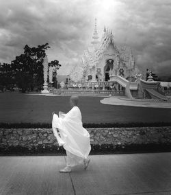 Midsection of woman with umbrella against sky