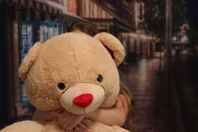 Girl holding stuffed toy at night