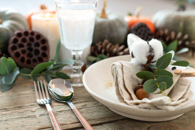 Autumn table decor. table setting with eucalyptus branches, pumpkins, cones and nuts, cotton flowers