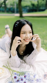 Portrait of young woman sitting on field