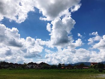 Houses on field against sky