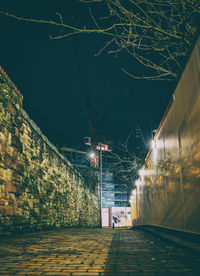 Illuminated street amidst buildings at night