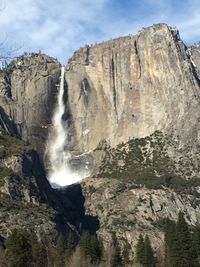 Low angle view of waterfall against sky