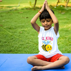 Asian smart kid doing yoga pose in the society park outdoor, children's yoga pose. 