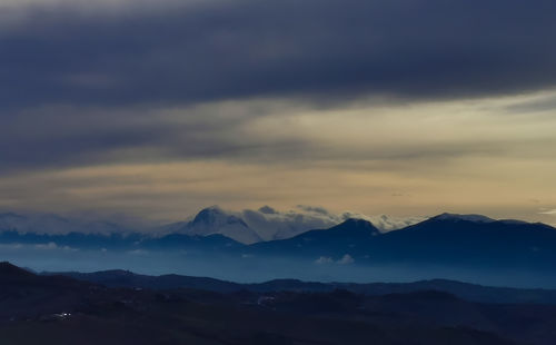 Scenic view of silhouette mountains against sky during sunset