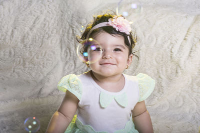 Portrait of cute baby girl smiling sitting at home