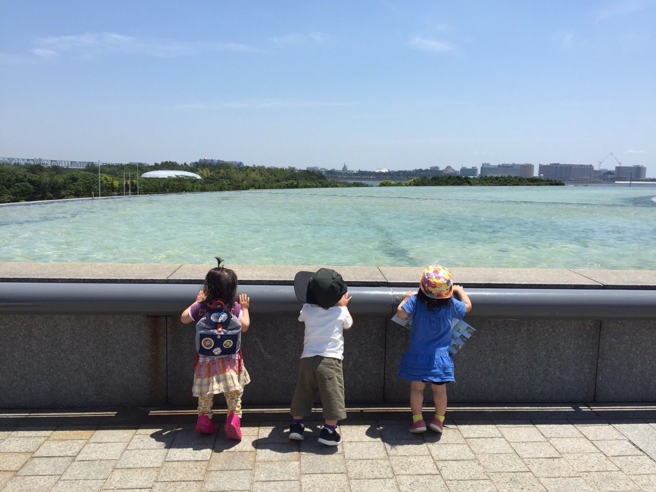 REAR VIEW OF PEOPLE STANDING BY SEA