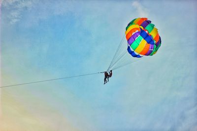 Low angle view of person paragliding against sky