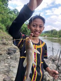 Portrait of young man holding fish