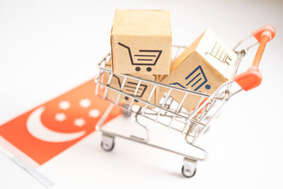 Close-up of miniature shopping cart against white background