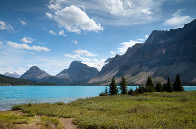 Scenic view of lake by mountains against sky