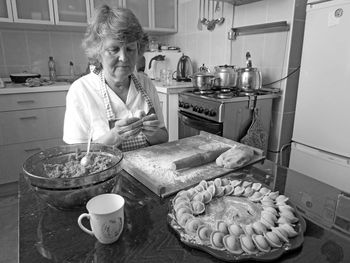 Woman preparing food at home typical russian ravioli - pilmeni