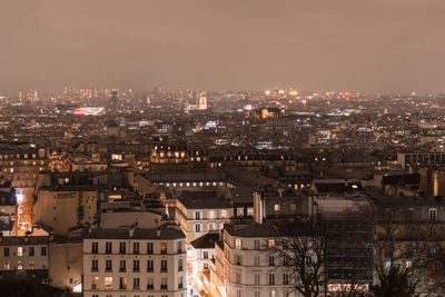 Illuminated cityscape against sky at night