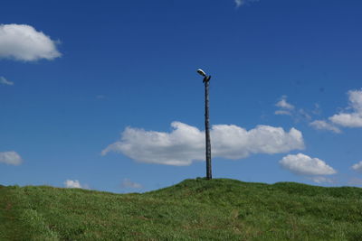 Low angle view of green field against blue sky