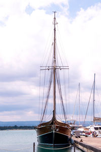 Sailboats moored on sea against sky