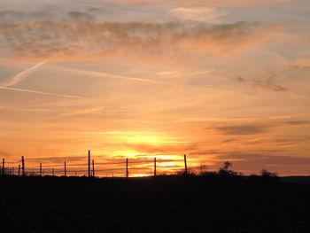 Scenic view of silhouette field against sky during sunset