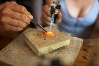 People making wedding ring on table in workshop