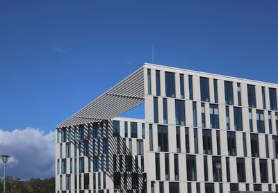 Low angle view of modern building against clear blue sky