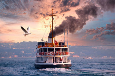 Boats in sea against sky during sunset