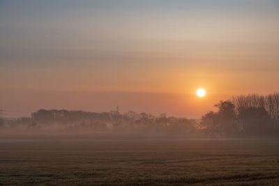 Scenic view of field against sky during sunset