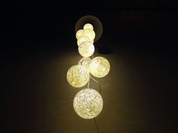 Low angle view of illuminated lamp against black background