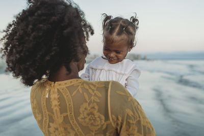 Young mother and daughter laughing in ocean