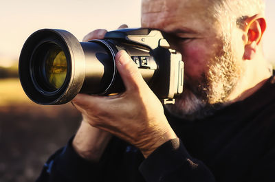 Close-up of man photographing with camera