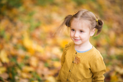 Portrait of smiling girl with autumn leaves