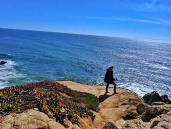 Woman looking at sea against sky