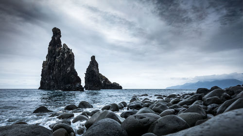 Rocks on beach against sky
