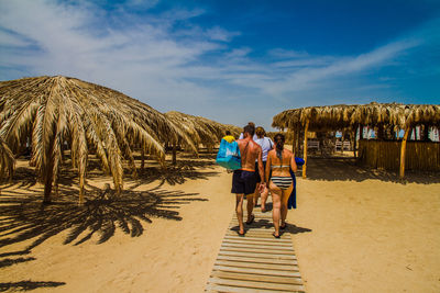 Rear view of people walking on beach