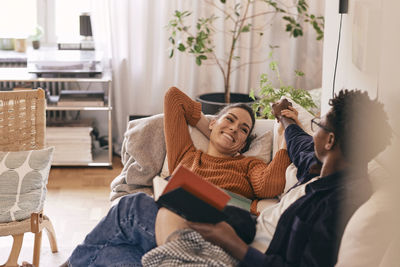 Happy couple spending leisure time on sofa at home