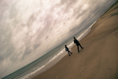 People on beach against sky