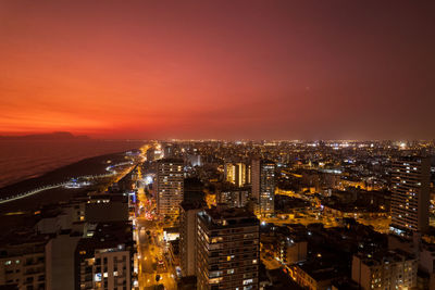 High angle view of illuminated cityscape against sky at night