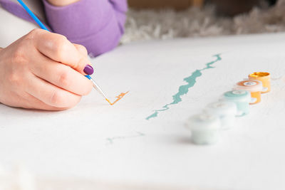 Midsection of woman drawing on paper