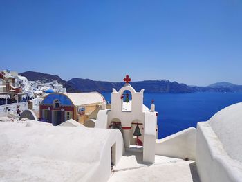 Panoramic view of sea and buildings against clear blue sky